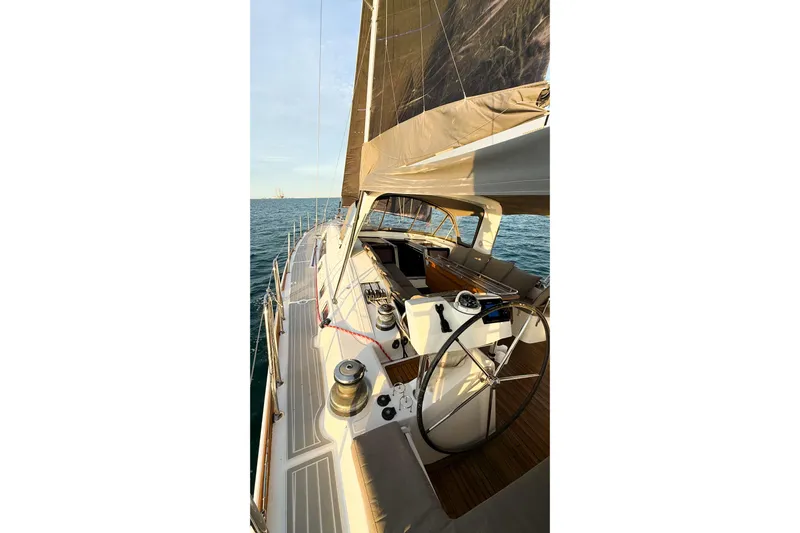  Yacht Photos Pics 2013 Beneteau Oceanis 58 yacht sailing on open sea, showcasing deck and helm.