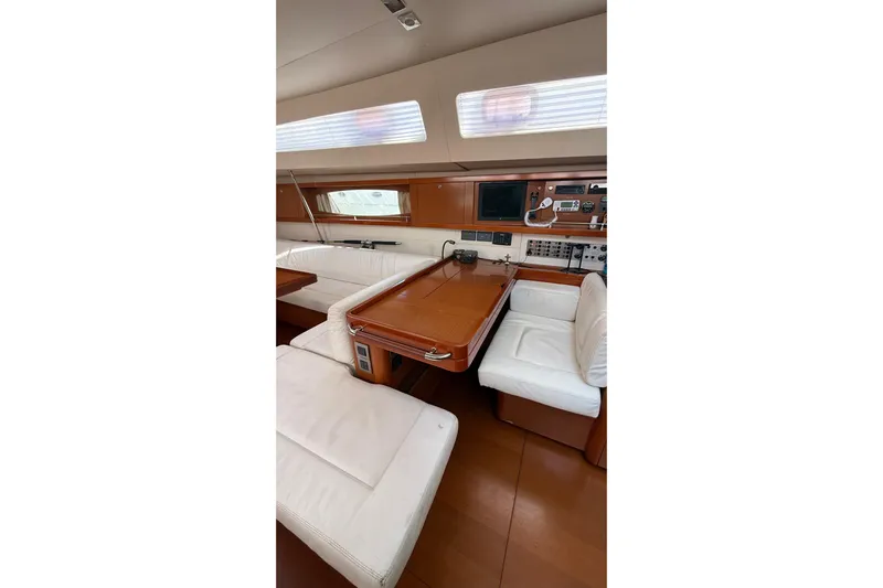  Yacht Photos Pics Luxurious interior of 2013 Beneteau Oceanis 58 yacht with white seating and wooden accents.