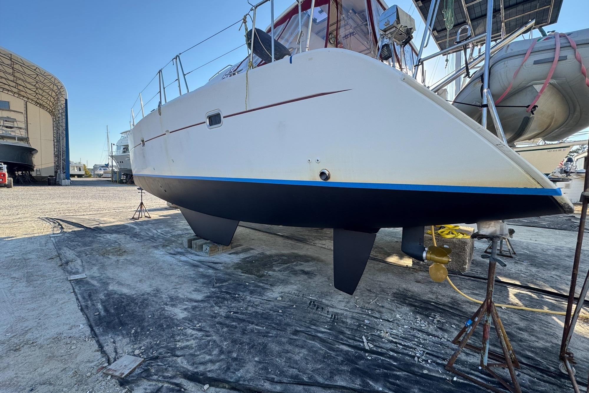 2004 Lagoon 380 catamaran on dry dock, undergoing maintenance in a boatyard.