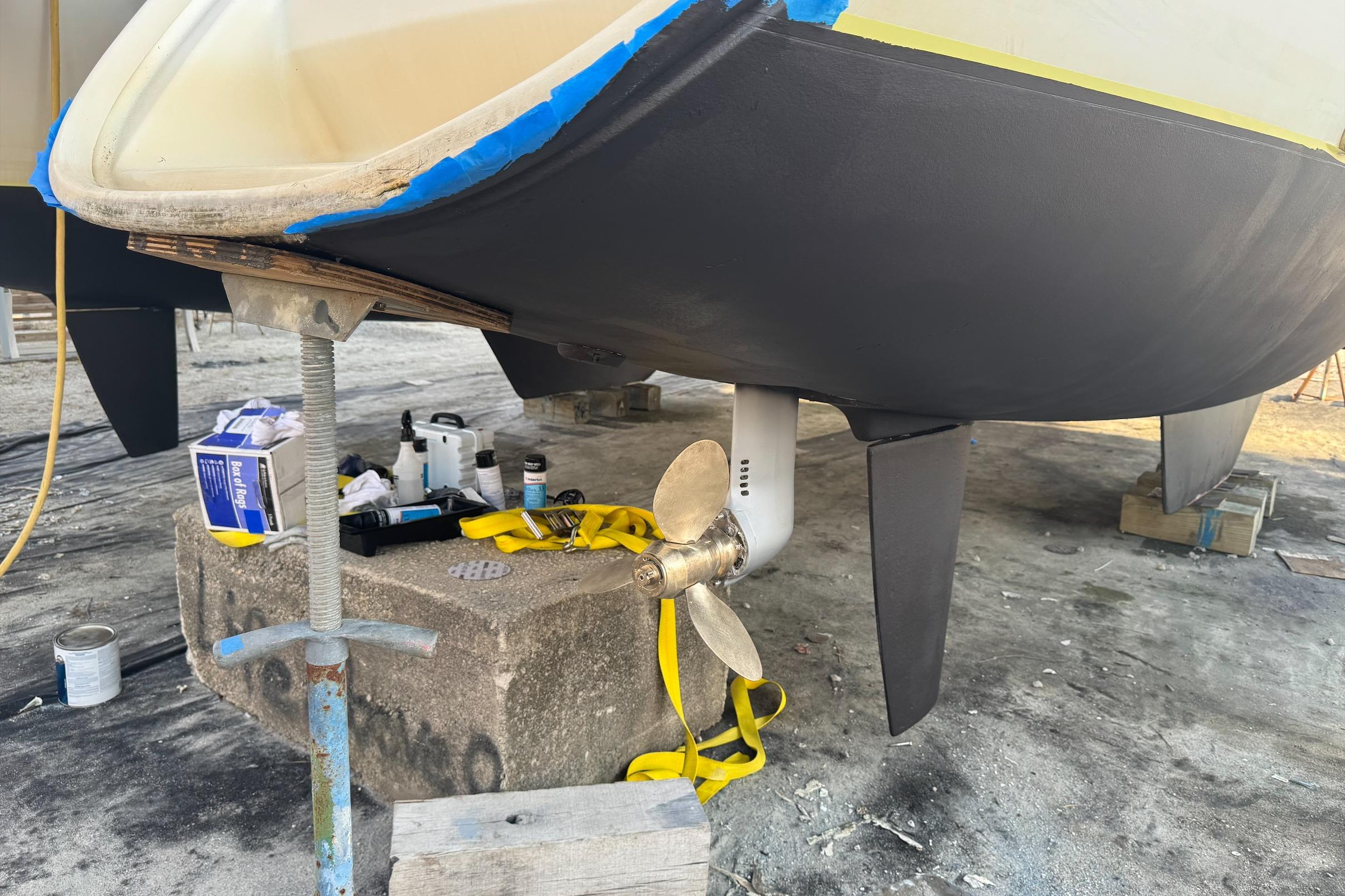 2004 Lagoon 380 catamaran under maintenance, showing propeller and hull details.