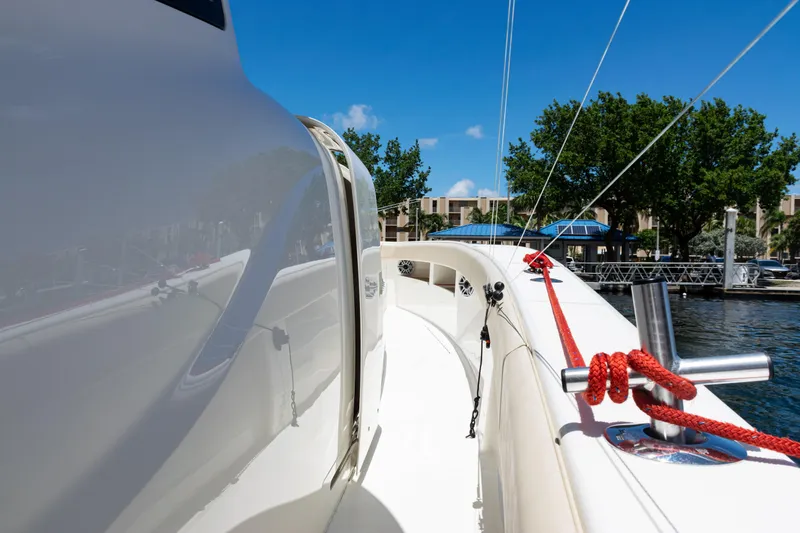  Yacht Photos Pics 2022 SeaVee 450z boat deck with red ropes, docked near trees and buildings.