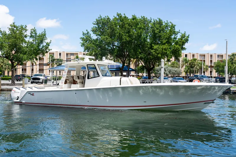  Yacht Photos Pics 2022 SeaVee 450z boat docked in a marina with trees and buildings in the background.