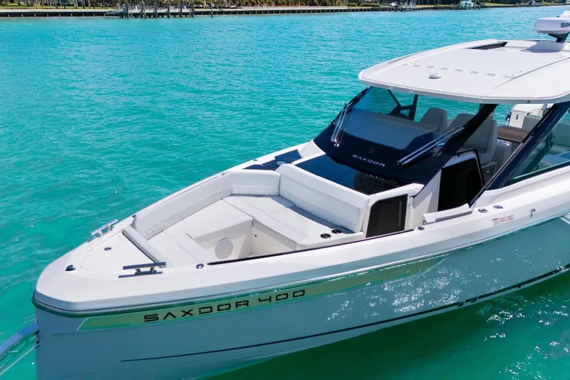  Yacht Photos Pics 2025 Saxdor 400 GTO luxury boat on turquoise water, showcasing sleek design and spacious deck.