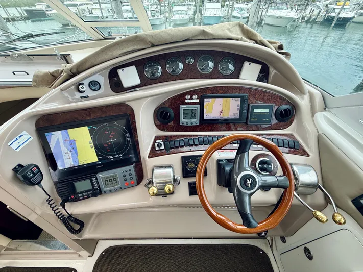  Yacht Photos Pics 2003 Sea Ray 480 Motor Yacht helm with navigation instruments and wooden steering wheel.
