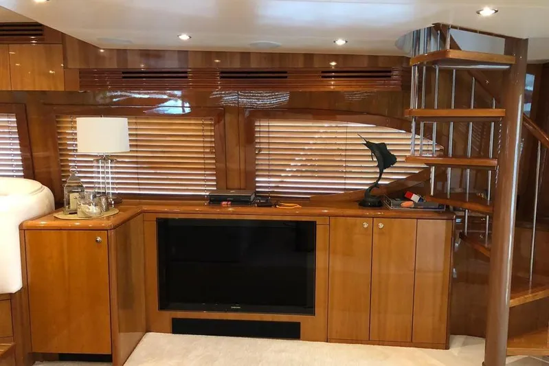 Show Time Yacht Photos Pics Luxurious interior of 2007 Hatteras 68 Convertible yacht with wooden cabinetry and spiral staircase.
