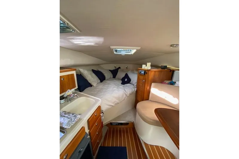 Good Fun Yacht Photos Pics Cozy cabin interior of 2006 Pursuit 3370 Offshore with bed, seating, and kitchenette.