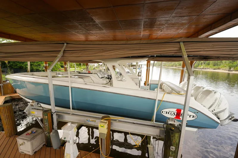  Yacht Photos Pics 2015 Cigarette 42 Huntress boat docked under a wooden canopy.