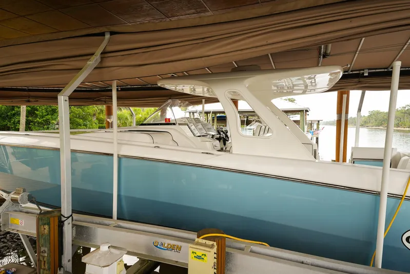  Yacht Photos Pics 2015 Cigarette 42 Huntress boat docked under a canopy, side view.