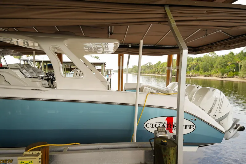  Yacht Photos Pics 2015 Cigarette 42 Huntress boat docked under a canopy on a serene river.
