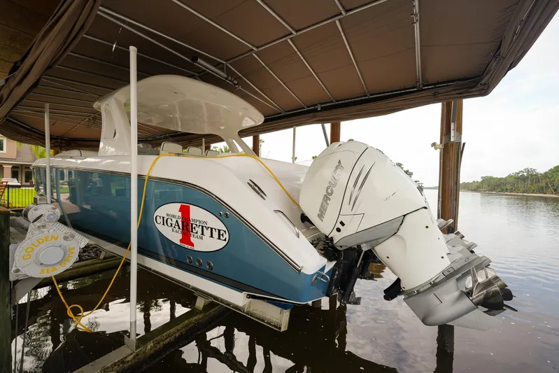  Yacht Photos Pics 2015 Cigarette 42 Huntress boat with Mercury outboard engines docked under a canopy.
