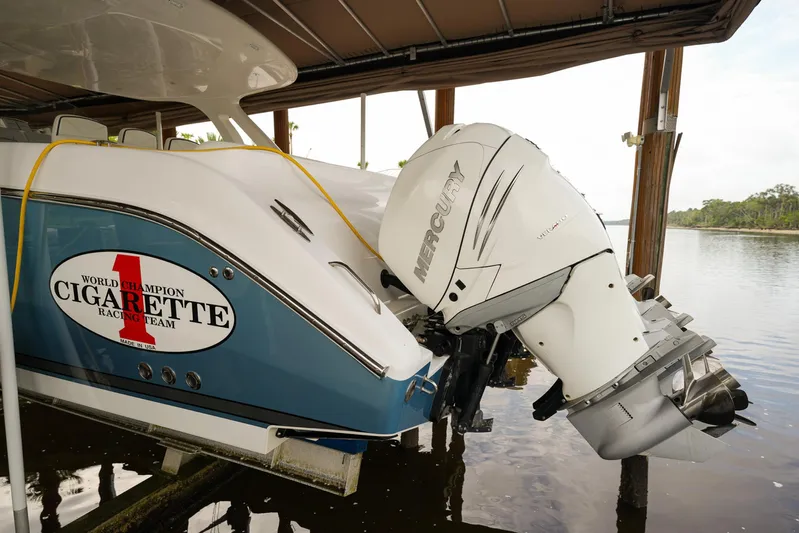  Yacht Photos Pics 2015 Cigarette 42 Huntress boat with Mercury outboard engine docked by the water.