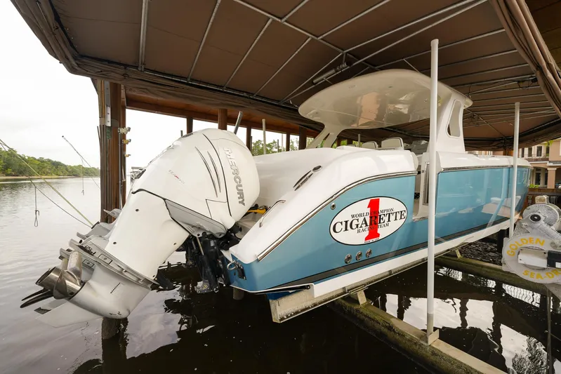  Yacht Photos Pics 2015 Cigarette 42 Huntress boat docked under a canopy, featuring powerful outboard engines.