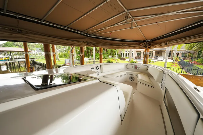  Yacht Photos Pics 2015 Cigarette 42 Huntress boat interior under canopy, showcasing sleek design and seating area.