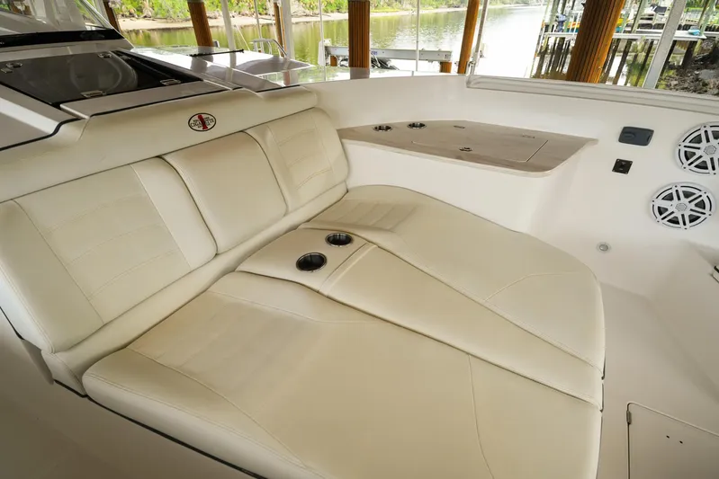  Yacht Photos Pics Luxurious seating on 2015 Cigarette 42 Huntress boat, featuring beige upholstery and cup holders.