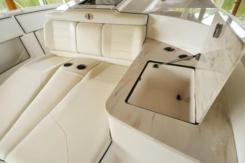  Yacht Photos Pics Luxurious interior of 2015 Cigarette 42 Huntress boat with white seating and storage compartment.