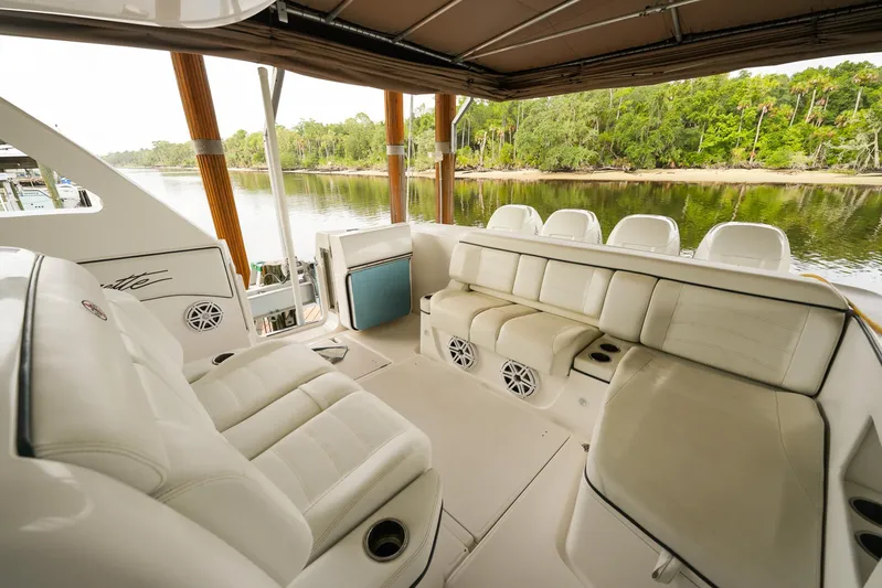  Yacht Photos Pics 2015 Cigarette 42 Huntress boat interior with white seating, docked by a scenic river.