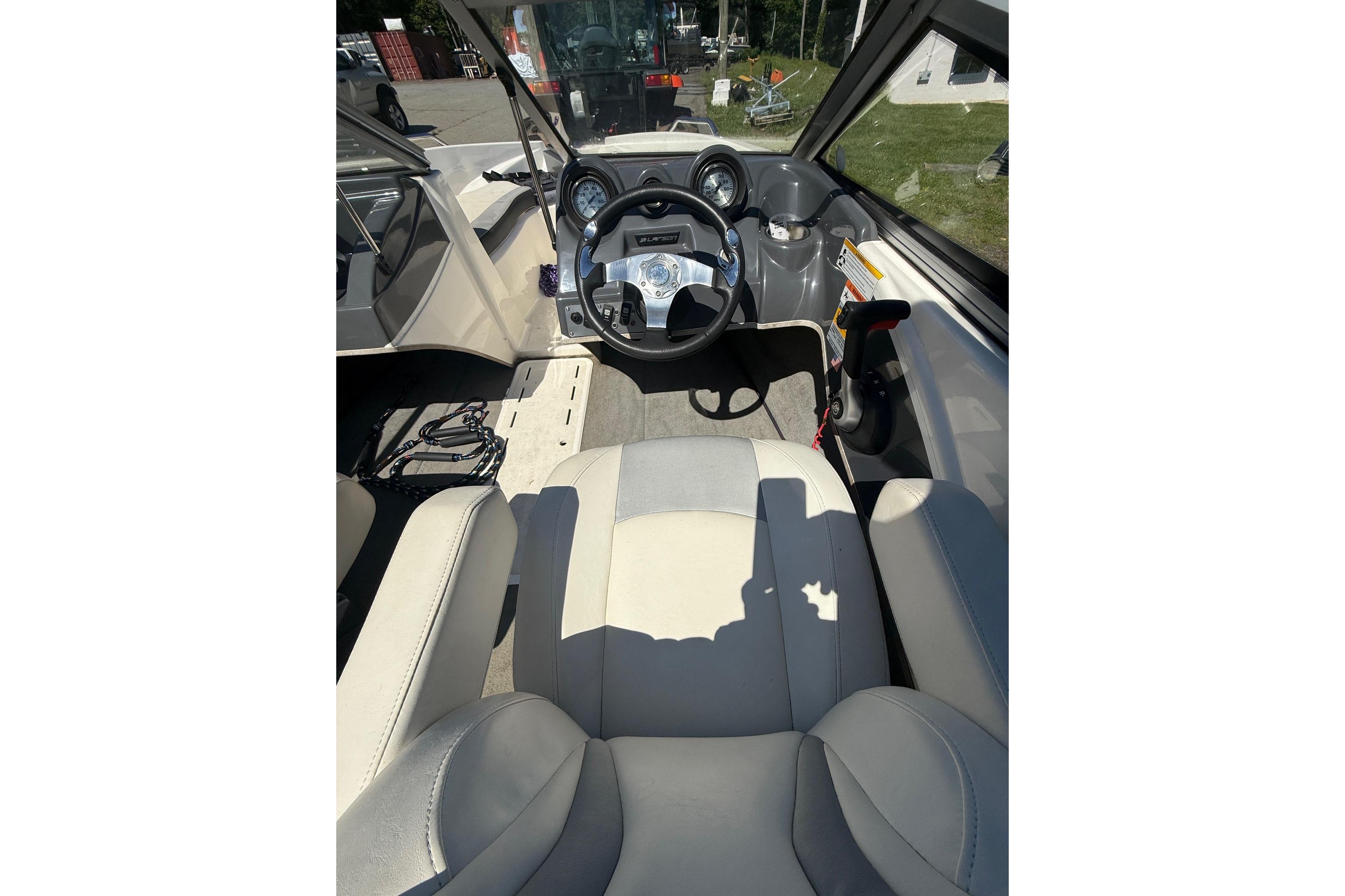 2014 Larson LX 160S OB boat interior with steering wheel and seating.