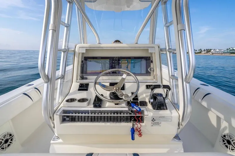 Nauti Gator Yacht Photos Pics 2014 SeaVee 34 boat console with steering wheel and navigation screens on calm ocean.