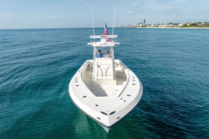 Nauti Gator Yacht Photos Pics 2014 SeaVee 34 boat cruising on clear blue ocean near coastline.
