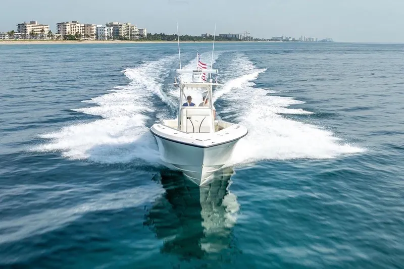 Nauti Gator Yacht Photos Pics 2014 SeaVee 34 boat cruising on open water near coastal cityscape.