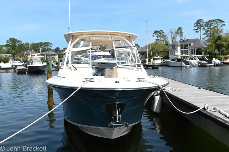  Yacht Photos Pics 2019 Grady-White Freedom 275 boat docked at a marina, surrounded by water and trees.