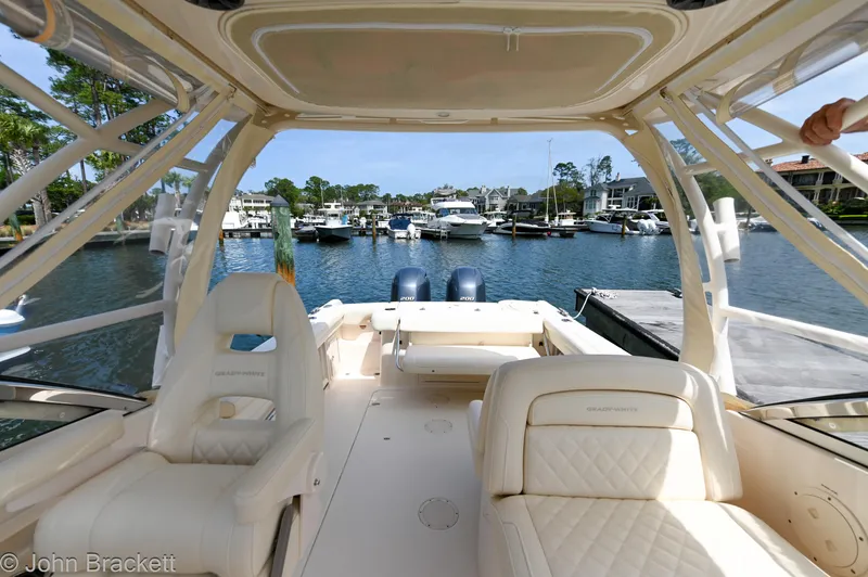  Yacht Photos Pics 2019 Grady-White Freedom 275 boat interior at marina, featuring comfortable seating and dual engines.