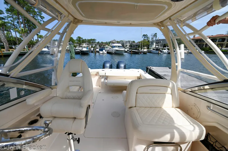  Yacht Photos Pics 2019 Grady-White Freedom 275 boat interior with luxurious seating at a marina.