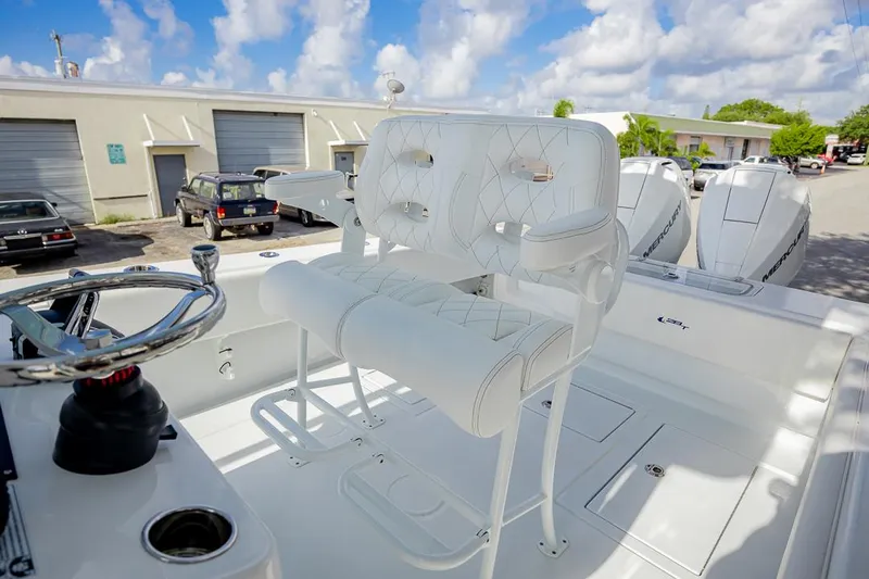  Yacht Photos Pics 2024 Contender 28 Tournament boat with white seating and steering wheel, parked outdoors.