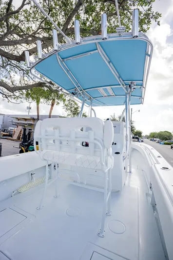  Yacht Photos Pics 2024 Contender 28 Tournament boat with blue canopy and rod holders, docked under trees.