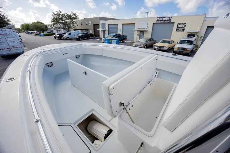  Yacht Photos Pics 2024 Contender 28 Tournament boat with open storage compartments, parked in an industrial area.