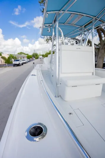  Yacht Photos Pics 2024 Contender 28 Tournament boat, sleek design, white deck, blue canopy, parked on street.