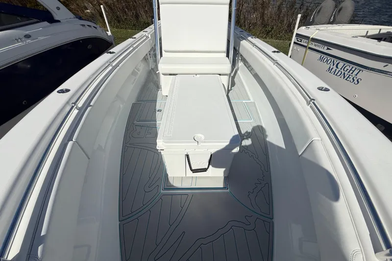  Yacht Photos Pics 2024 Contender 28 Tournament boat interior with seating and storage, docked beside other boats.
