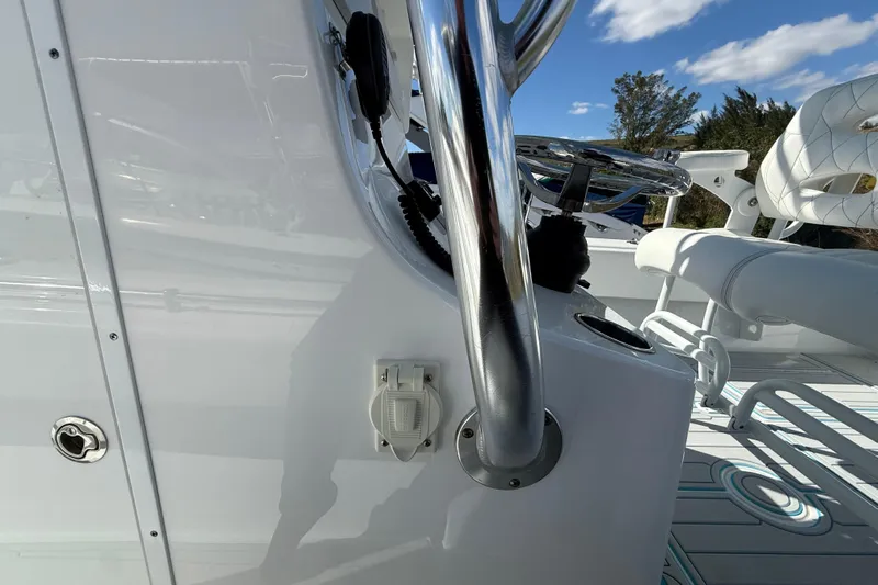  Yacht Photos Pics 2024 Contender 28 Tournament boat interior with steering wheel and seating, under a clear blue sky.