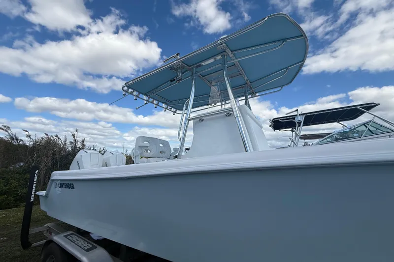  Yacht Photos Pics 2024 Contender 28 Tournament boat with blue canopy under a cloudy sky.