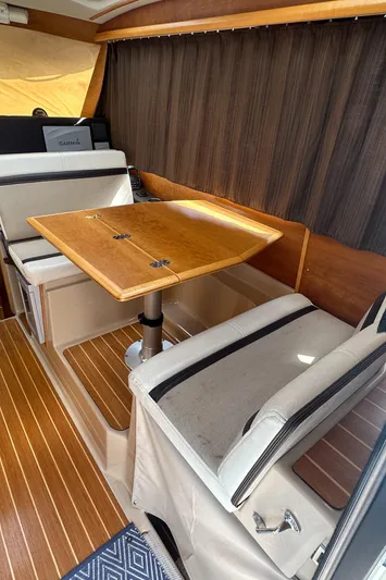Cutwater 28 Yacht Photos Pics 2016 Cutwater 28 interior with wooden table and seating, featuring elegant design and wood flooring.