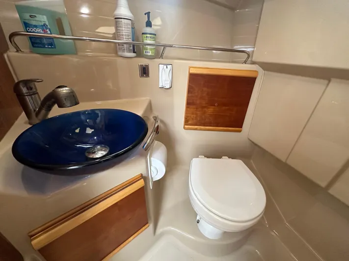 Cutwater 28 Yacht Photos Pics Compact bathroom in a 2016 Cutwater 28 boat with blue sink and toilet.