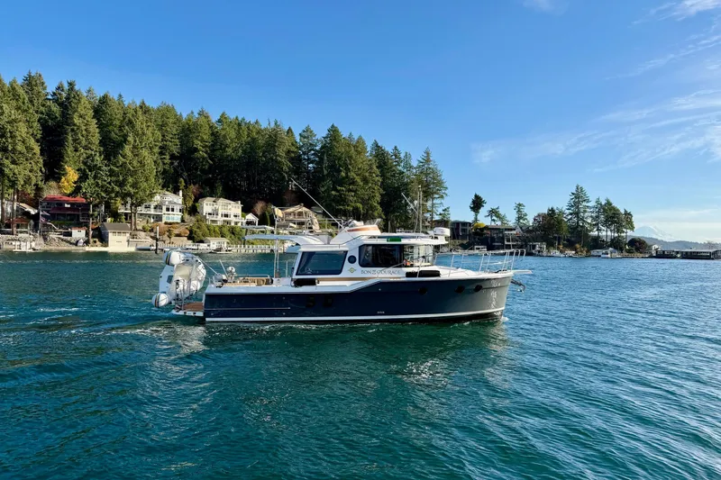 Bon Courage Yacht Photos Pics 2018 Ranger Tugs R-29 CB cruising on a scenic lake with forested shoreline.