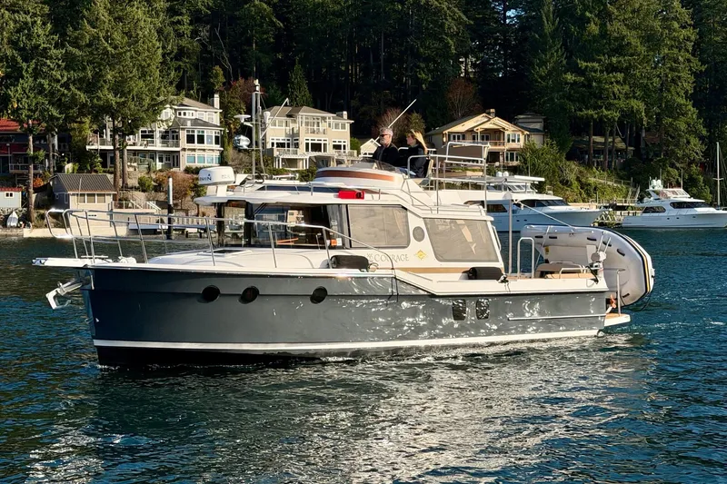 Bon Courage Yacht Photos Pics 2018 Ranger Tugs R-29 CB cruising on a scenic waterfront with houses and trees.