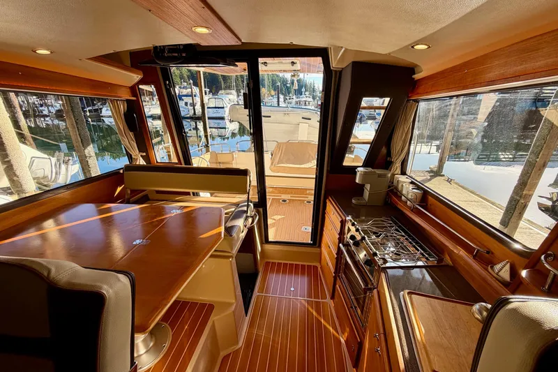 Bon Courage Yacht Photos Pics Interior of 2018 Ranger Tugs R-29 CB, featuring wood finishes and marina view.