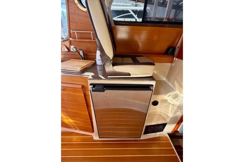 Bon Courage Yacht Photos Pics 2018 Ranger Tugs R-29 CB interior with wooden cabinetry and compact fridge.
