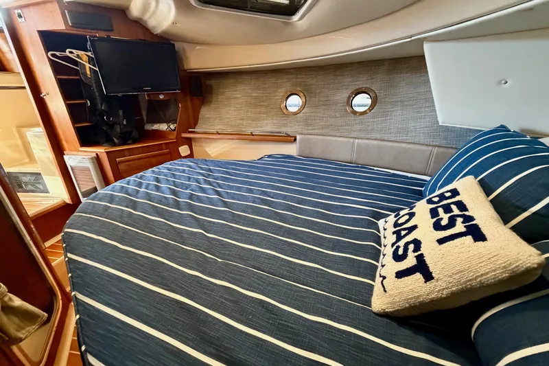 Bon Courage Yacht Photos Pics 2018 Ranger Tugs R-29 CB cabin interior with striped bedding and "Best Coast" pillow.