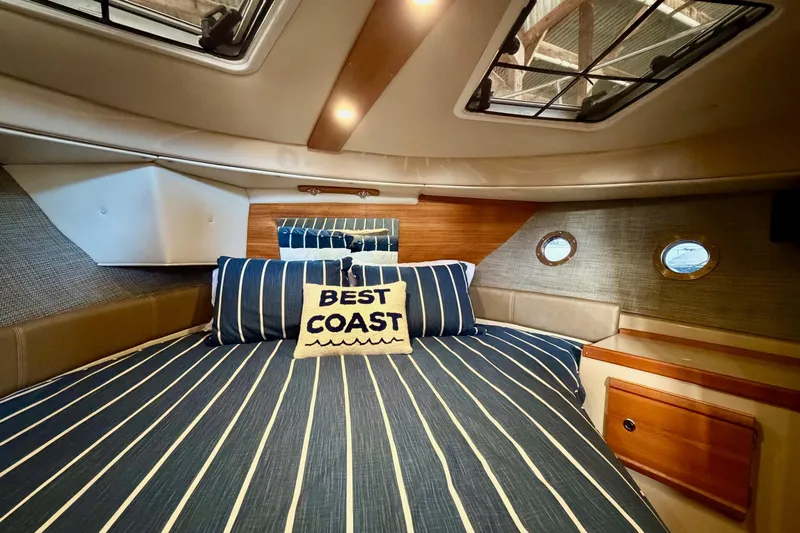 Bon Courage Yacht Photos Pics 2018 Ranger Tugs R-29 CB cabin with striped bedding and "Best Coast" pillow.