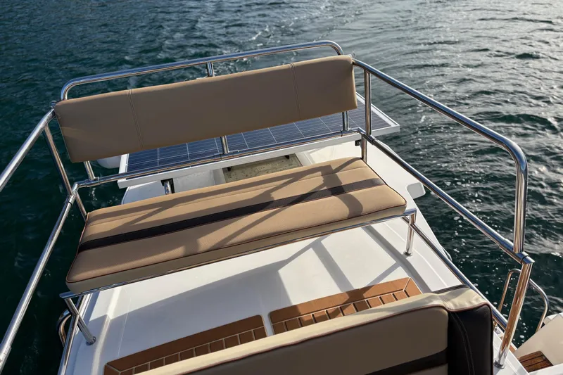 Bon Courage Yacht Photos Pics 2018 Ranger Tugs R-29 CB boat deck with cushioned seating and railing on water.