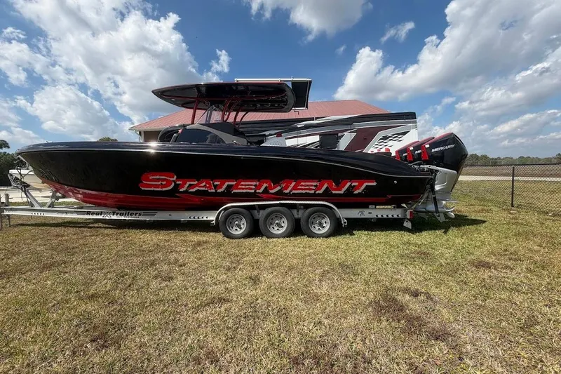  Yacht Photos Pics 2018 Statement 380 Open boat on trailer, parked on grass under a partly cloudy sky.