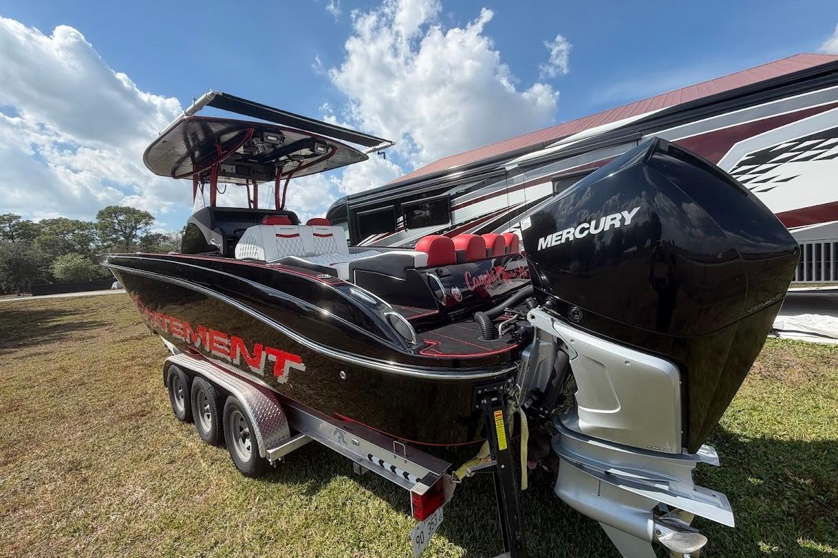2018 Statement 380 Open boat with Mercury engine, parked on grass under a blue sky.
