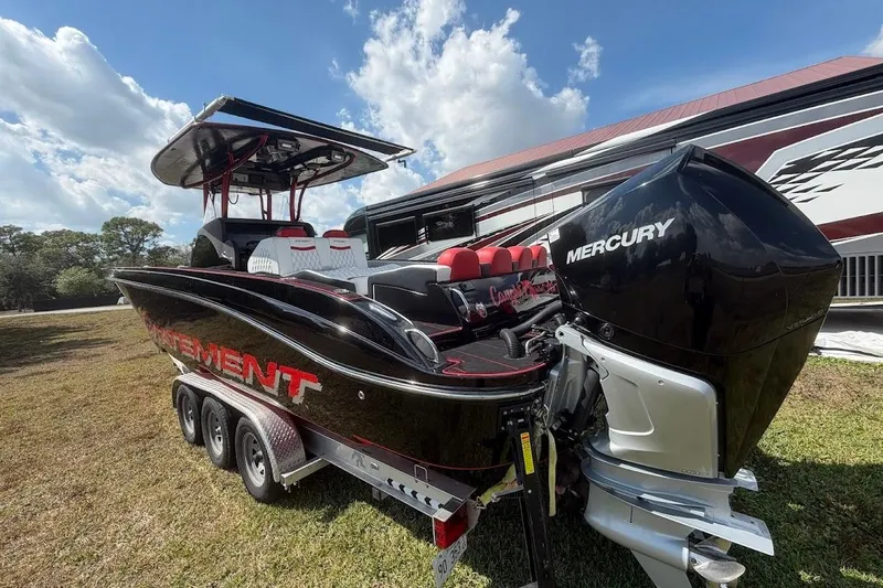  Yacht Photos Pics 2018 Statement 380 Open boat with Mercury engine, parked on grass under a blue sky.