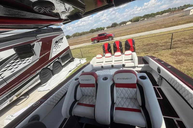  Yacht Photos Pics 2018 Statement 380 Open boat interior with luxury seating, parked near a red truck and RV.