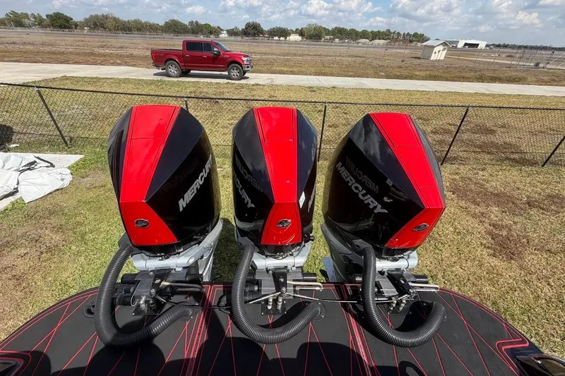  Yacht Photos Pics Three Mercury outboard engines on a 2018 Statement 380 Open boat, with a red truck in the background.