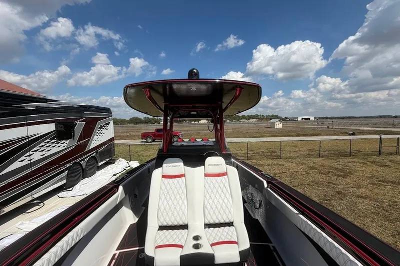  Yacht Photos Pics 2018 Statement 380 Open boat with white seating, parked near RV under blue sky.