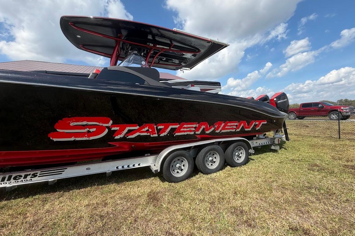 2018 Statement 380 Open boat on trailer, black and red design, parked outdoors.